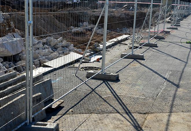 a construction site with temporary fence panels to ensure security and safety